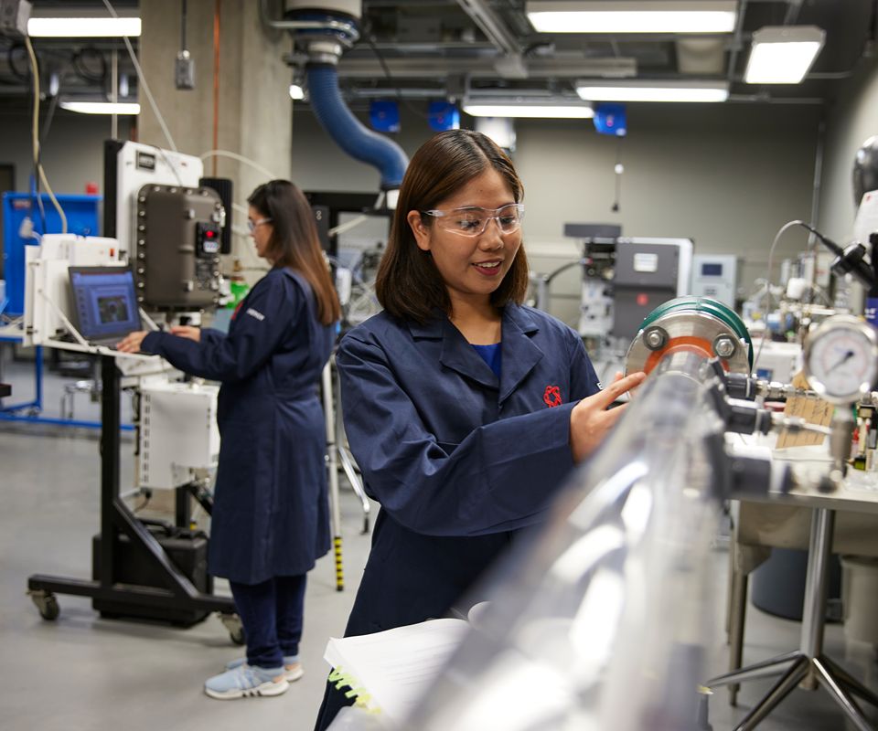 Technician adjusting equipment in a lab.