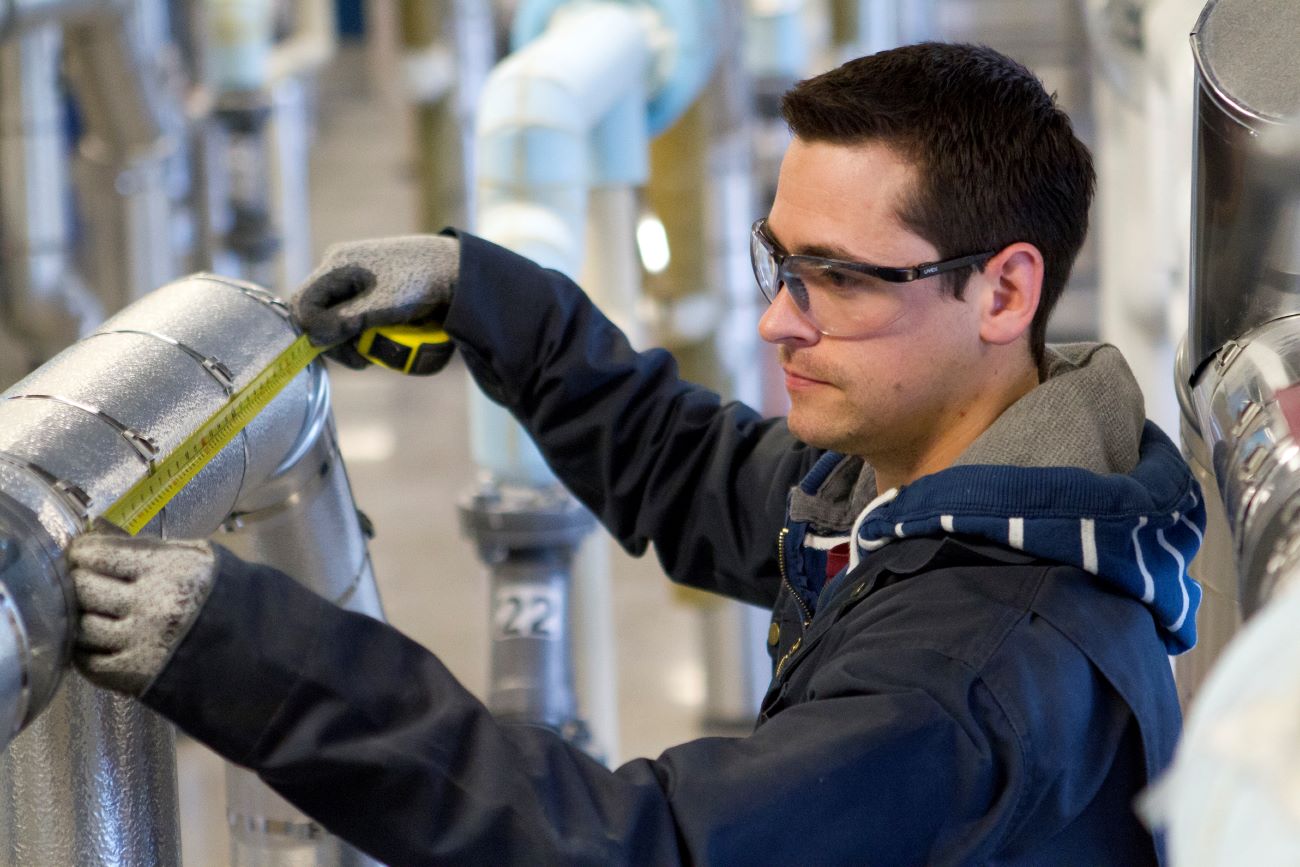 A student using a tape measure in a lab