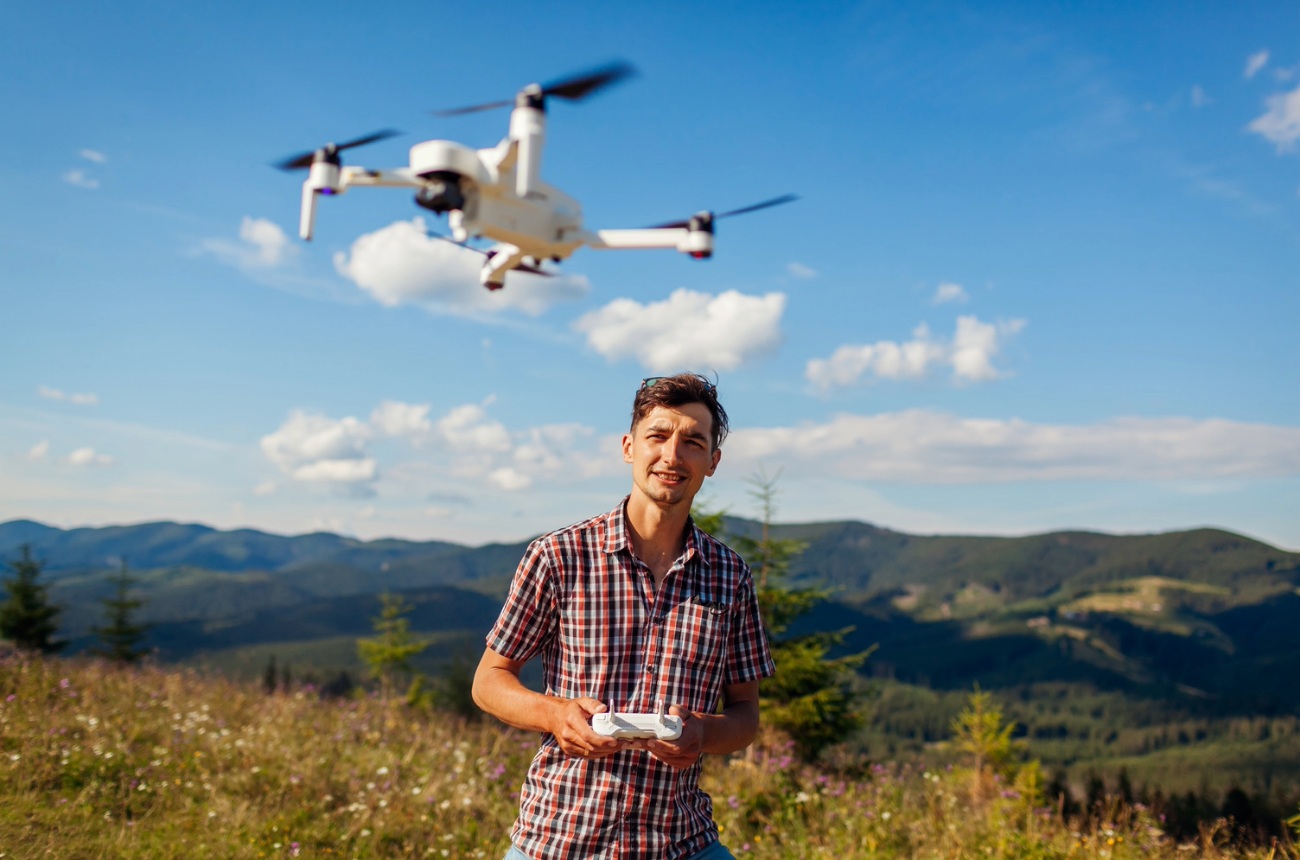 Student flying a drone in a field.