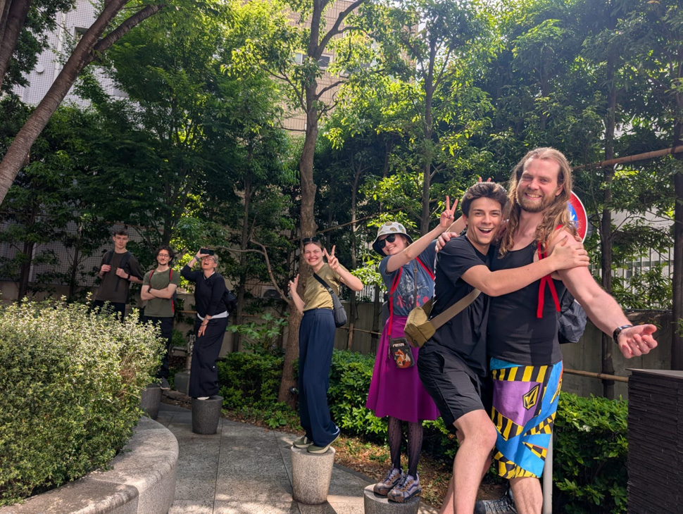 Group of people posing along a tree-lined outdoor path.