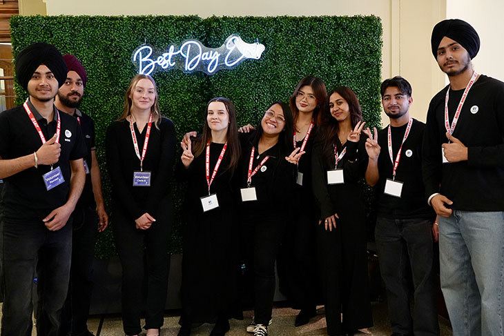  A group of business administration and film and video production students with a backdrop that says best day ever