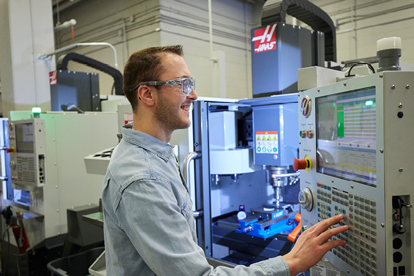 A student pressing buttons on a machine in a lab